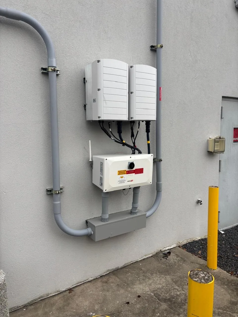 Wall-mounted inverters and electrical disconnects at an installed site